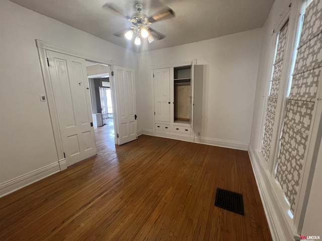 unfurnished bedroom with visible vents, wood-type flooring, baseboards, and ceiling fan