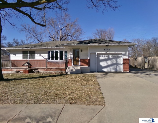 ranch-style home with brick siding, concrete driveway, a garage, and fence