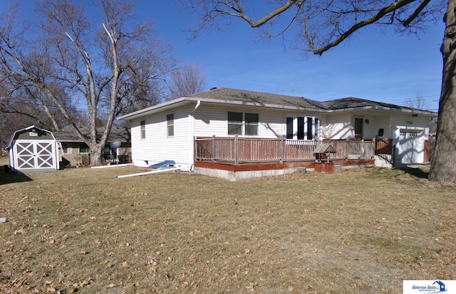 back of house featuring an outbuilding, a shed, a garage, a deck, and a lawn