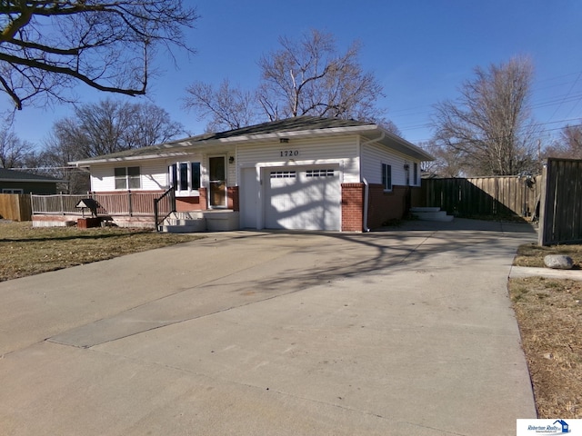 ranch-style house featuring a garage, fence, brick siding, and driveway