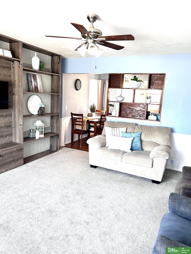 carpeted living room with a ceiling fan