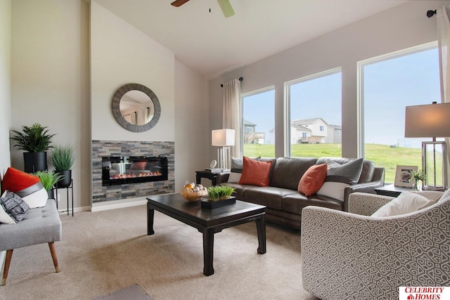 living area featuring a ceiling fan, baseboards, carpet floors, high vaulted ceiling, and a glass covered fireplace