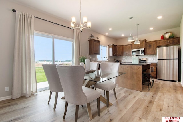 dining room with recessed lighting, an inviting chandelier, and light wood finished floors