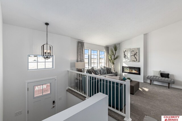 8238 N 175th St, Bennington, NE 68007 - foyer featuring carpet, baseboards, lofted ceiling, a glass covered fireplace, and a notable chandelier