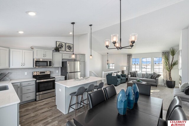 8238 N 175th St, Bennington, NE 68007 - dining area featuring a chandelier, recessed lighting, lofted ceiling, and dark wood-style flooring