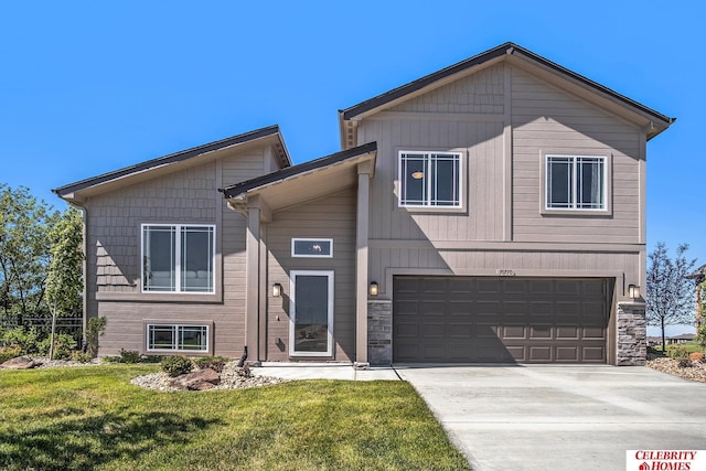 view of front of house featuring a front lawn, an attached garage, and driveway