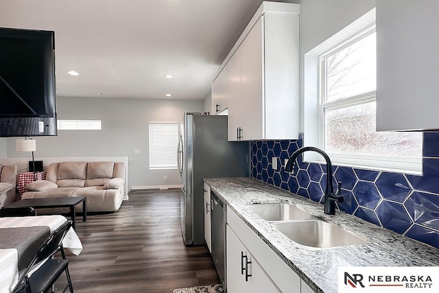 kitchen with tasteful backsplash, plenty of natural light, stainless steel appliances, and a sink