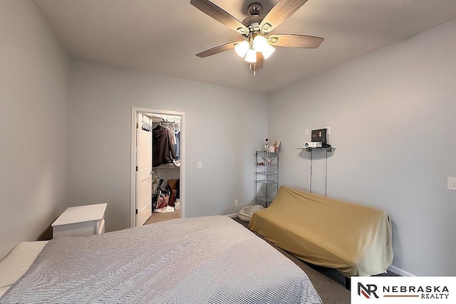 bedroom with a walk in closet and ceiling fan