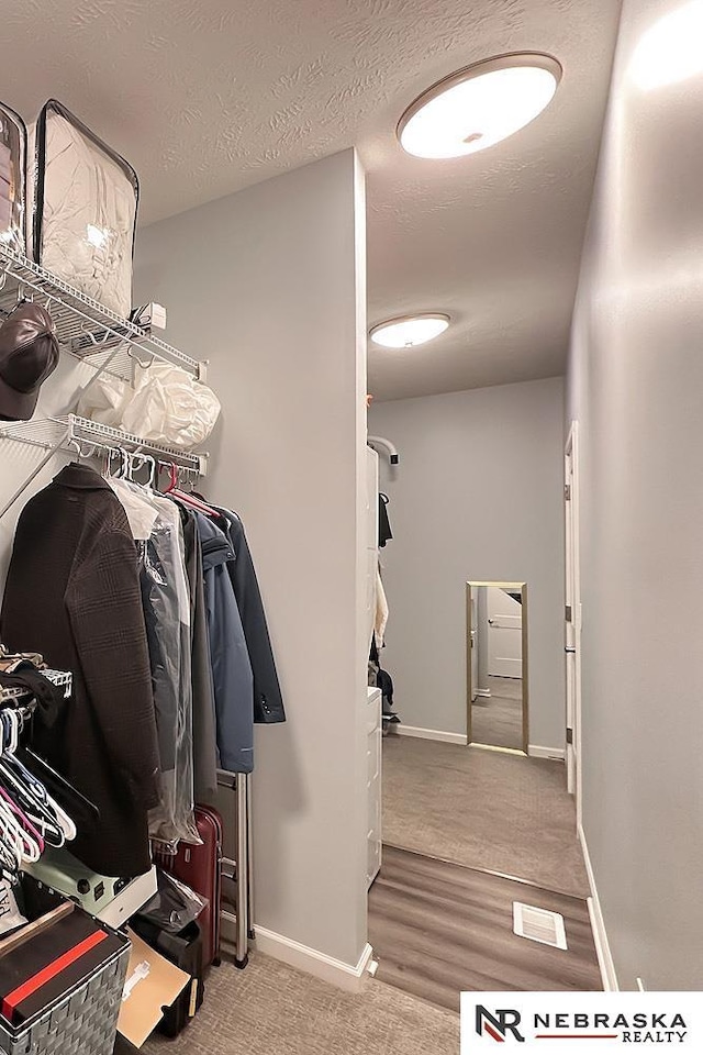 spacious closet featuring visible vents and wood finished floors