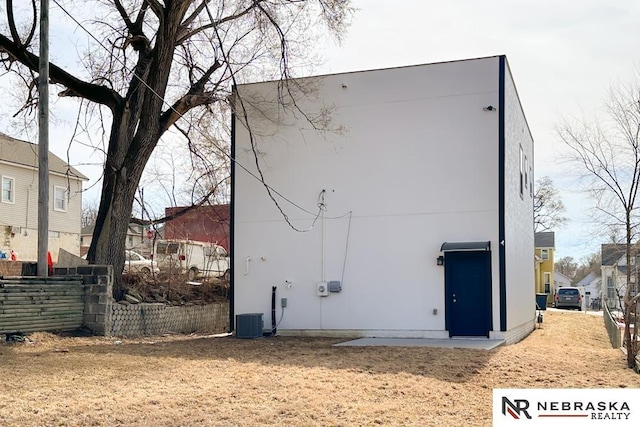 view of side of home featuring stucco siding and fence