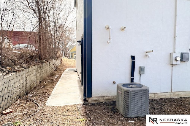 view of side of property featuring cooling unit and stucco siding