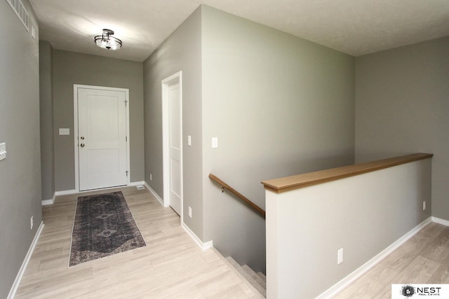 entryway featuring visible vents, baseboards, and wood finished floors