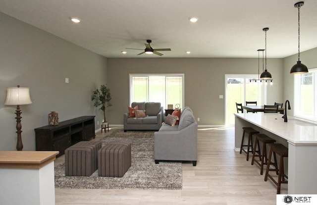 living room with a ceiling fan, recessed lighting, light wood-type flooring, and a wealth of natural light