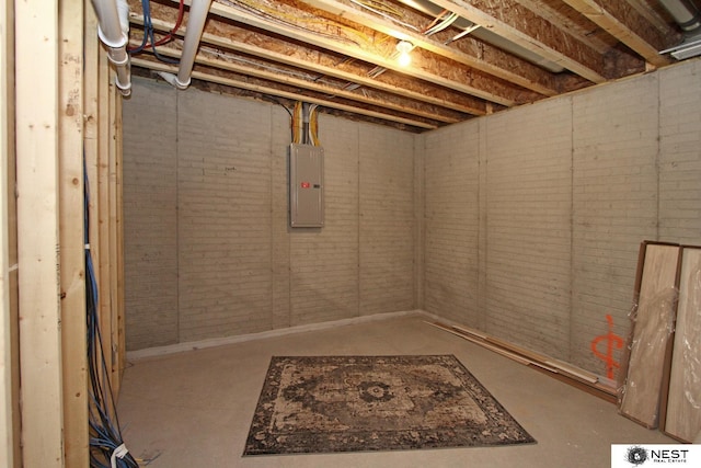 unfinished below grade area with electric panel and brick wall