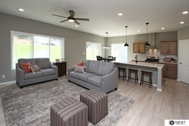 living area with recessed lighting, light wood-type flooring, and a ceiling fan