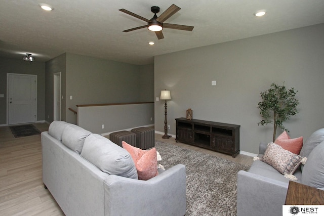 living area with baseboards, recessed lighting, light wood-type flooring, and ceiling fan