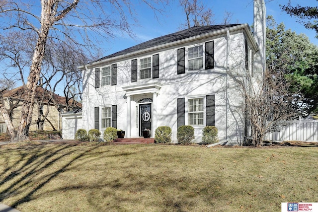 colonial-style house with a front yard and fence