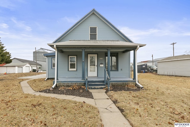 bungalow with a detached garage, an outbuilding, and covered porch