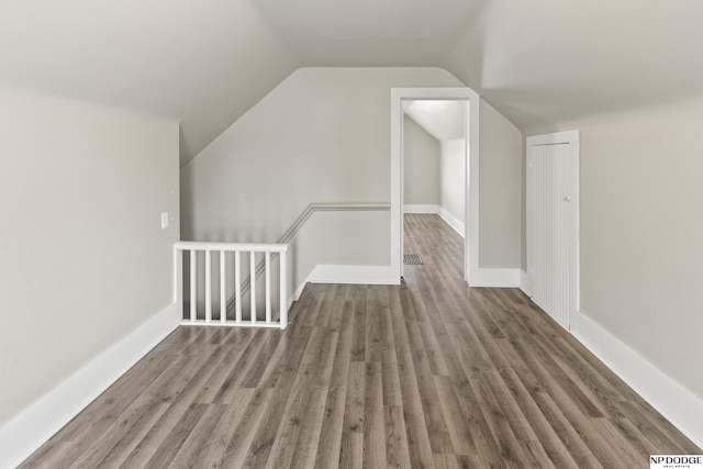 bonus room with vaulted ceiling, baseboards, and wood finished floors