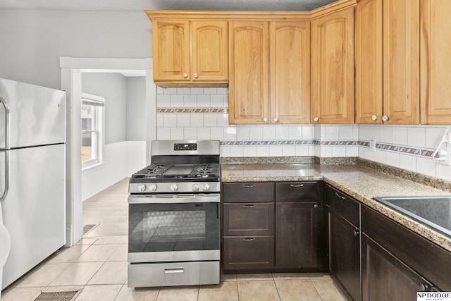 kitchen featuring decorative backsplash, light tile patterned floors, a sink, and stainless steel appliances