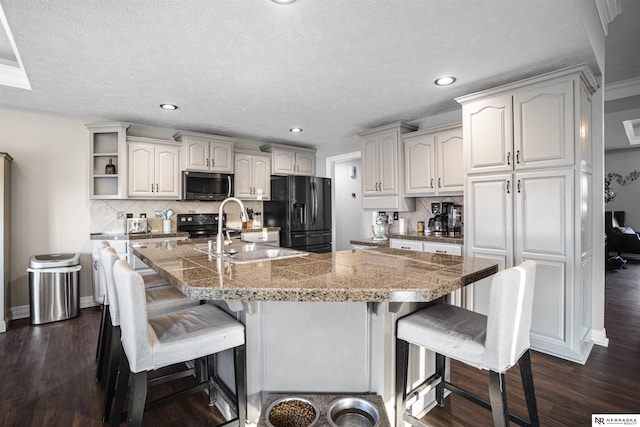 kitchen featuring a kitchen bar, black appliances, a sink, open shelves, and dark wood-style floors