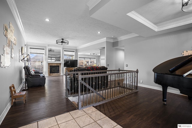 interior space with crown molding, a fireplace, baseboards, and a textured ceiling