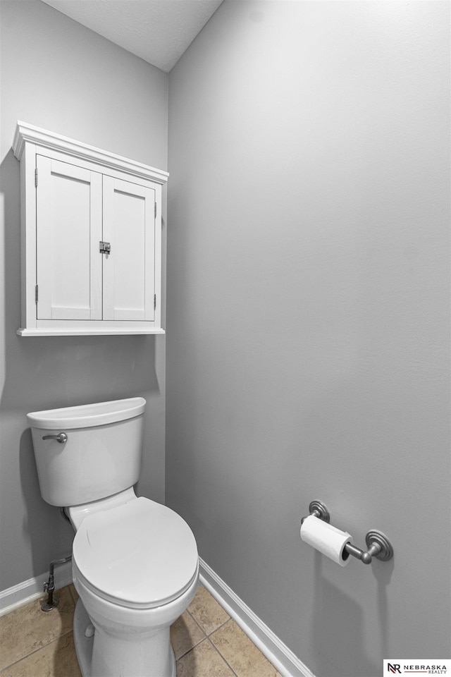 bathroom featuring tile patterned floors, toilet, and baseboards