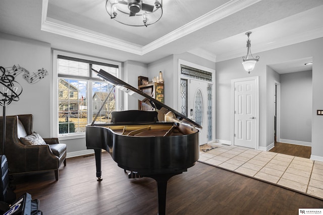 sitting room with baseboards, a raised ceiling, wood finished floors, and crown molding