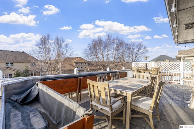 wooden terrace featuring outdoor dining area and a residential view