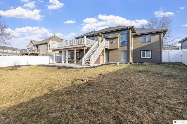 back of house featuring a patio, a gate, a wooden deck, a fenced backyard, and a lawn