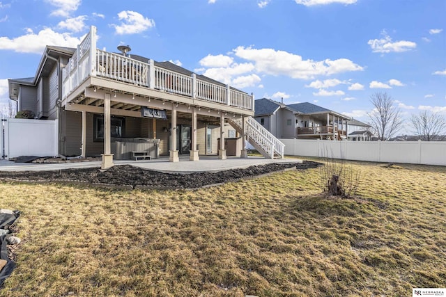 rear view of house featuring a hot tub, fence, a wooden deck, stairs, and a patio