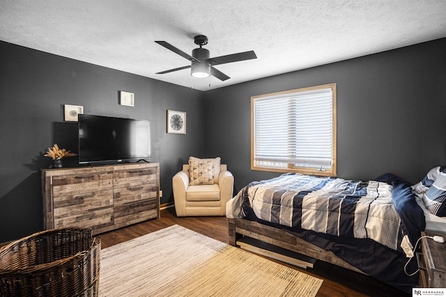 bedroom with a textured ceiling, a ceiling fan, and wood finished floors