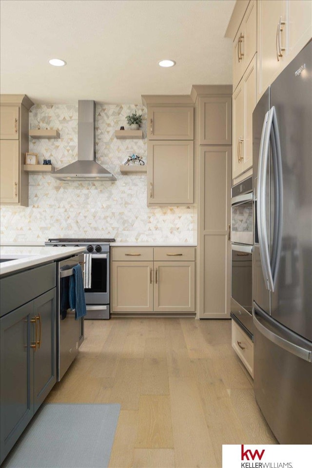 kitchen featuring stainless steel appliances, wall chimney exhaust hood, light countertops, and open shelves