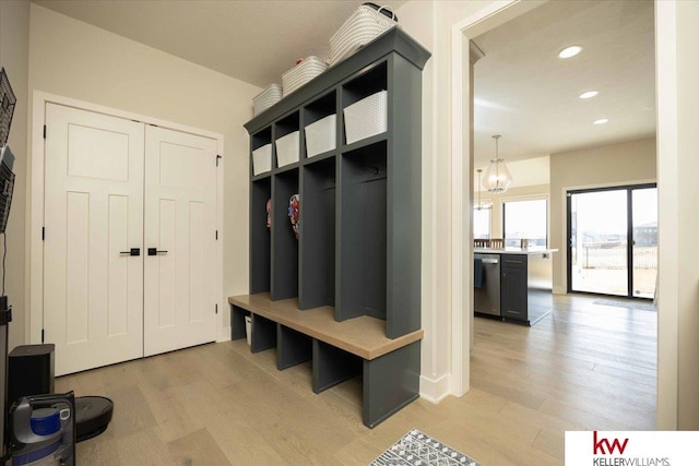 mudroom with recessed lighting, light wood-type flooring, and an inviting chandelier