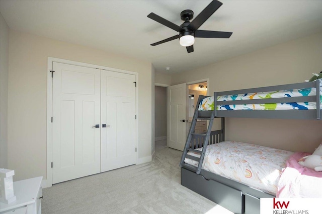 bedroom with a closet, light carpet, baseboards, and ceiling fan