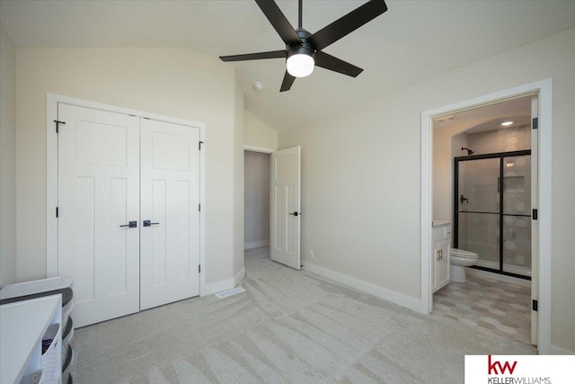 unfurnished bedroom featuring baseboards, a closet, lofted ceiling, and light carpet