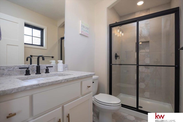 full bath featuring vanity, a shower stall, and toilet