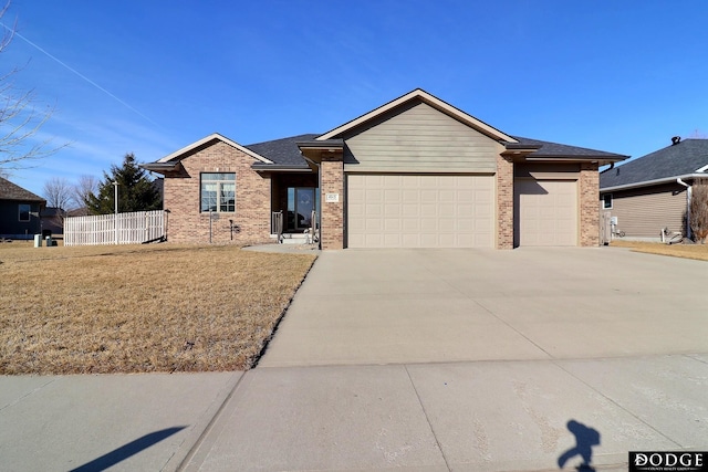 single story home with brick siding, fence, a garage, and driveway