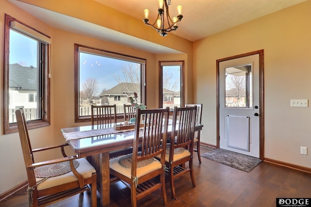 dining area with a notable chandelier, baseboards, dark wood-style flooring, and a wealth of natural light