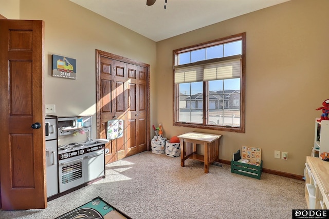 interior space featuring baseboards, carpet, and ceiling fan