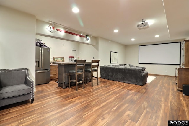 home theater with recessed lighting, a dry bar, and wood finished floors