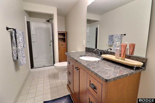 bathroom with baseboards, a stall shower, vanity, and tile patterned flooring