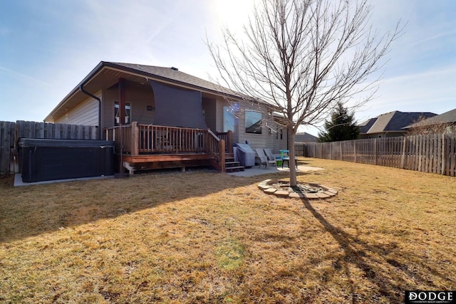 back of house featuring a wooden deck, a lawn, a fenced backyard, and a patio area