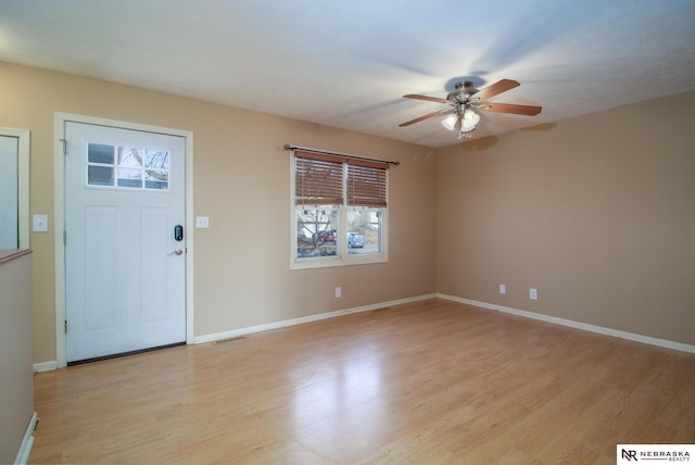 entryway with a ceiling fan, visible vents, light wood-type flooring, and baseboards