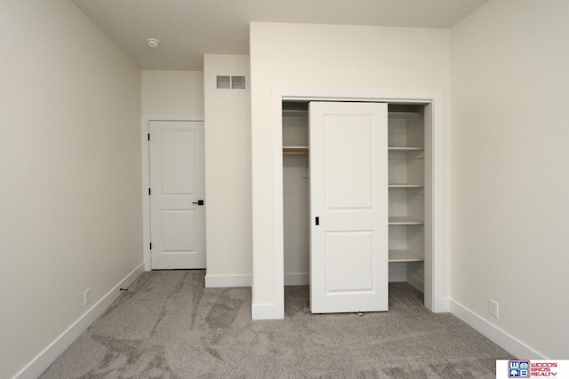 unfurnished bedroom with baseboards, visible vents, carpet floors, and a closet