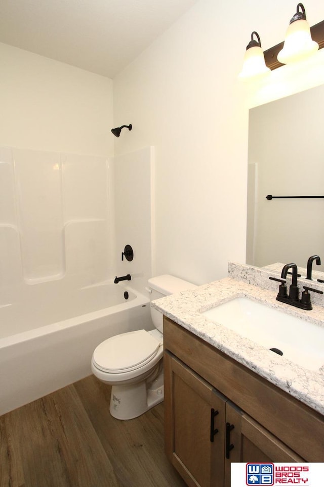 full bathroom with tub / shower combination, toilet, vanity, and wood finished floors