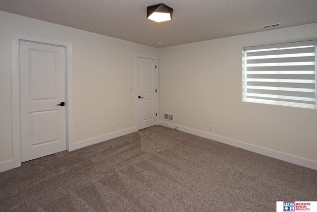 carpeted spare room with visible vents and baseboards