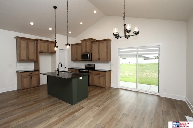 kitchen featuring a sink, dark countertops, brown cabinetry, and stainless steel appliances