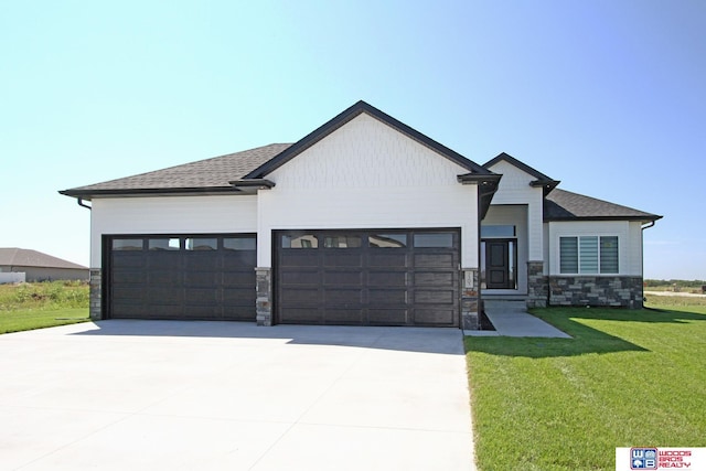 view of front facade with a garage, stone siding, a front lawn, and driveway