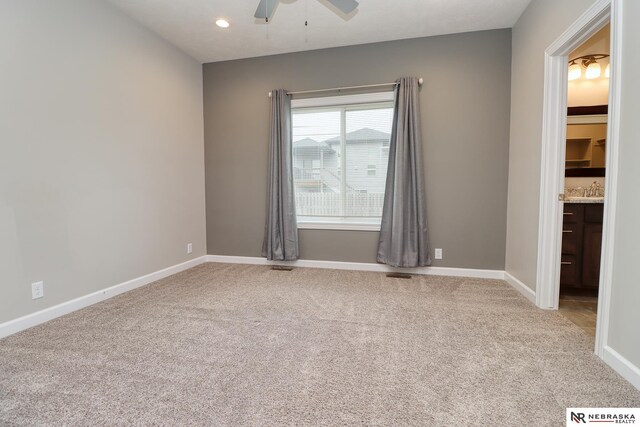 spare room with visible vents, baseboards, light colored carpet, recessed lighting, and a ceiling fan